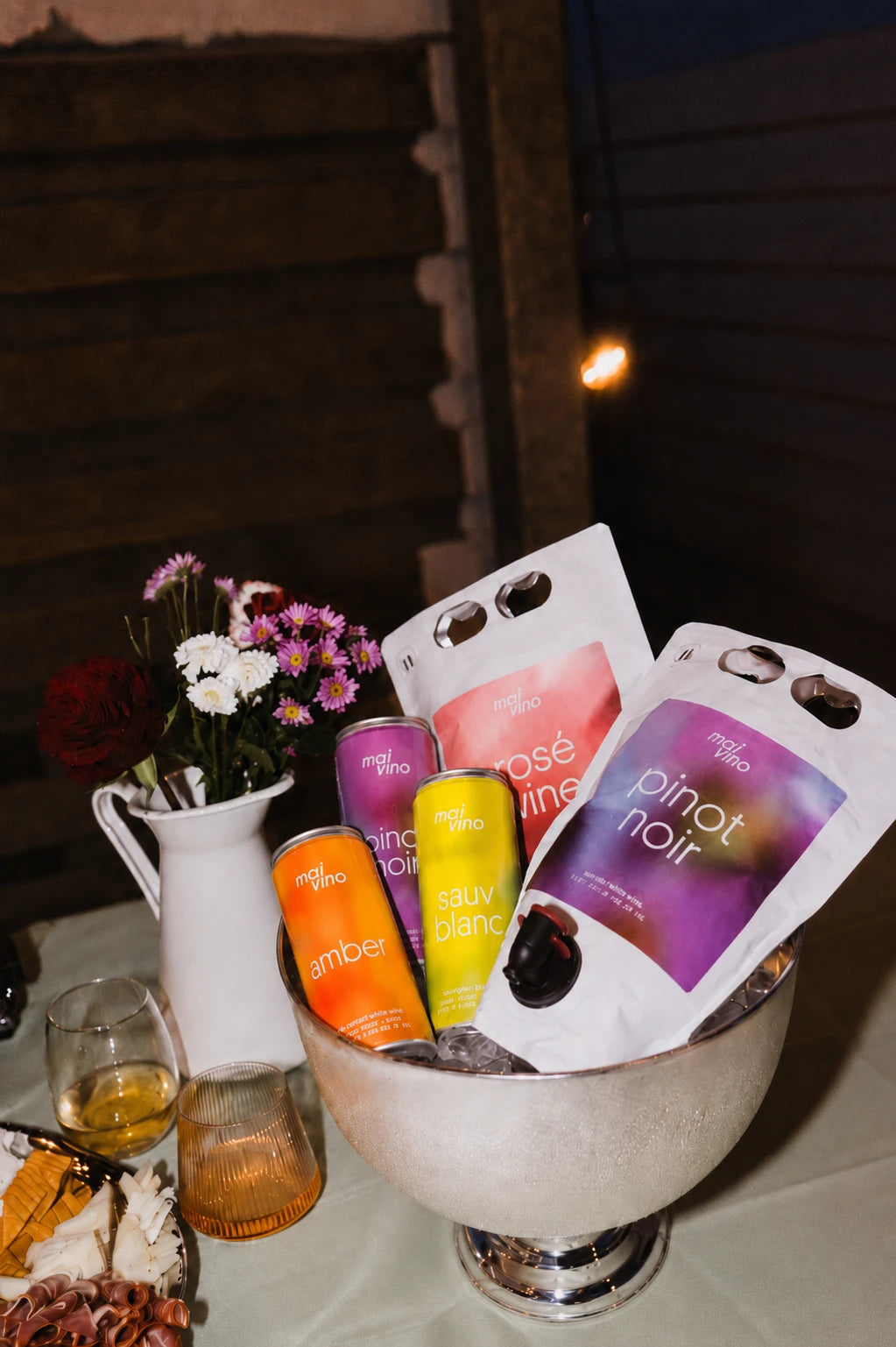 Mai Vino Rosé and Pinot Noir pouches with Amber, Pinot Noir and Sauv Blanc cans in an ice bucket at a party